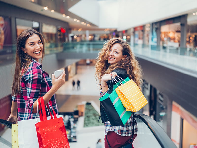two girl friends shopping in shopping centre