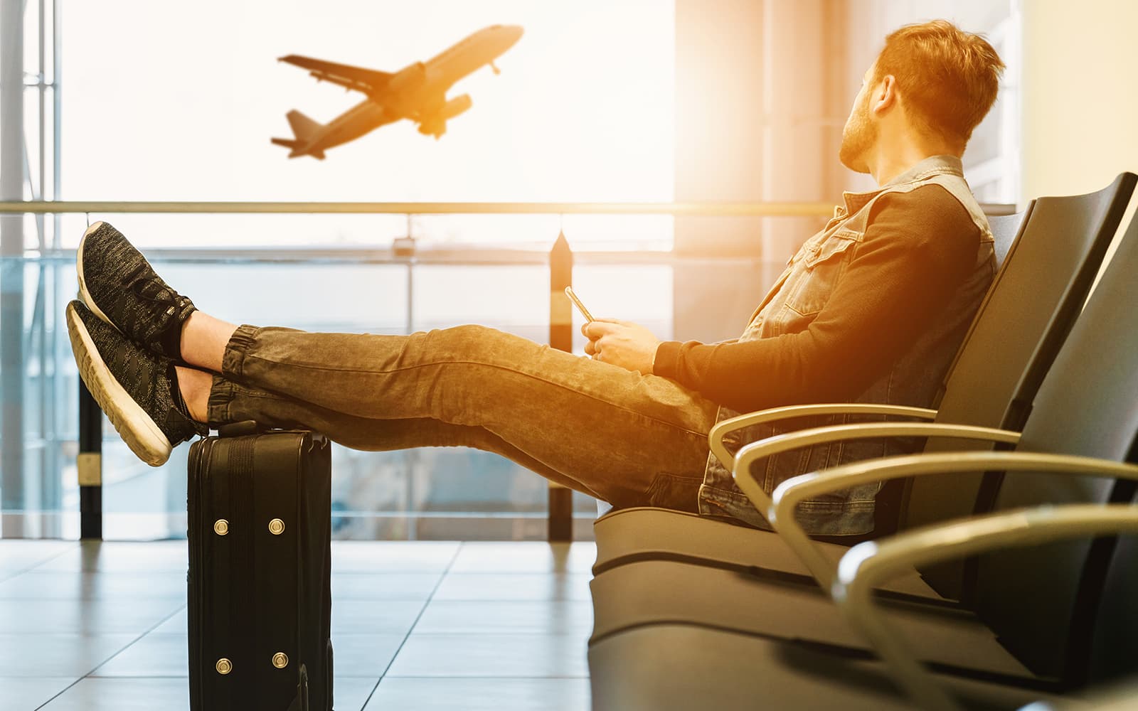 Man staring at departing airplane at the airport